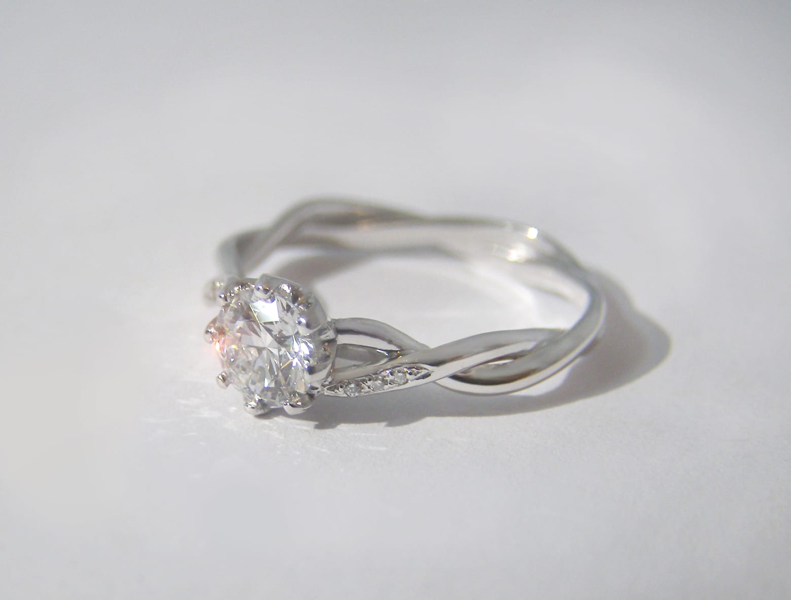 Twisted platinum band with central created diamond and small diamonds